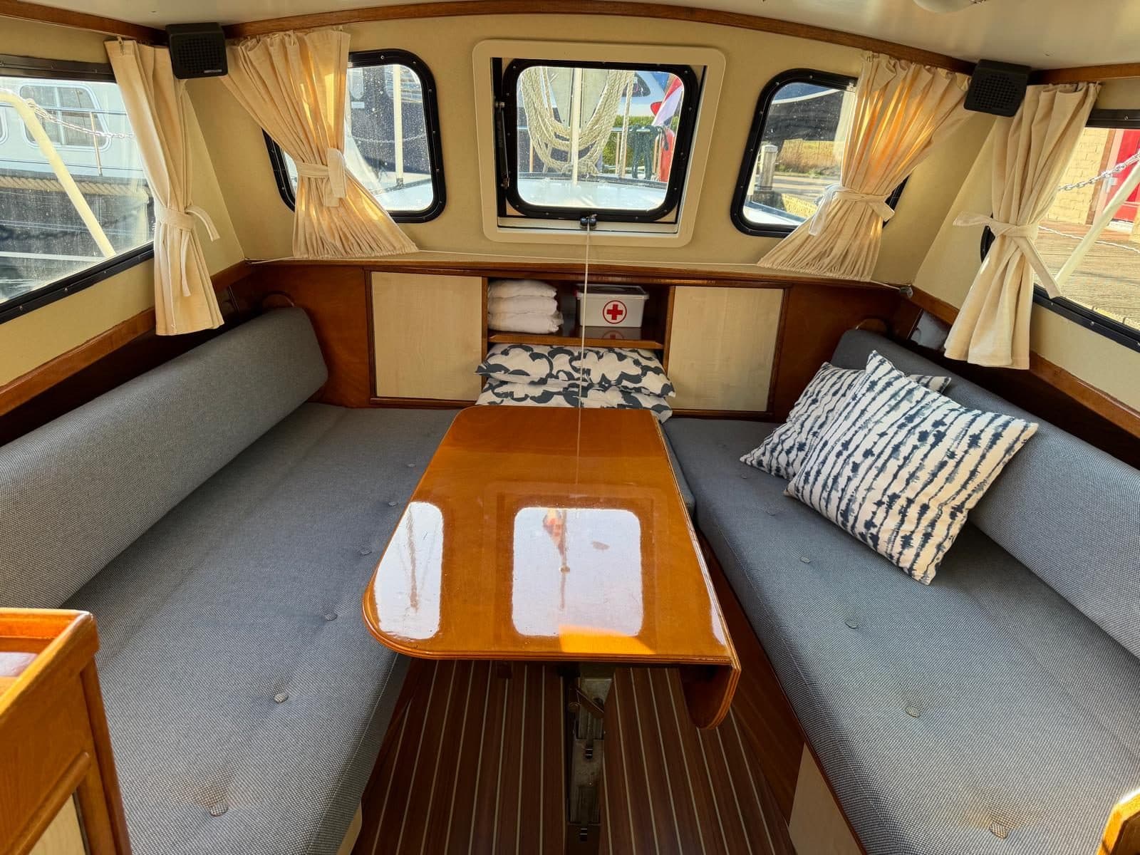 Salon met grijze banken, sierkussens en teak tafel